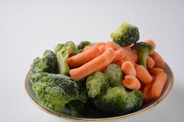 Small frozen pieces of  broccoli and carrots.  Healthy food. Frozen vegetables