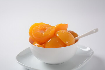 Sweet canned peaches in the ceramic bowl