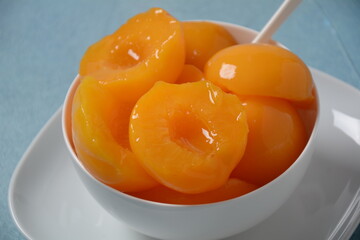 Sweet canned peaches in the ceramic bowl