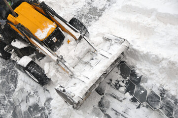 Removing snow accumulations using a tractor with attachments.