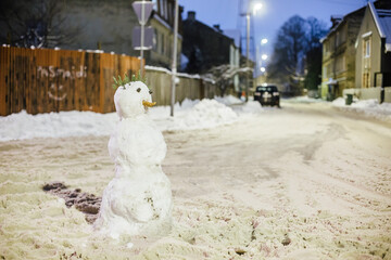 Very snowy street in the neighborhood. Residents have erected a snowman in the middle of a large...