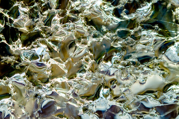 Transparent ice cracked crystals with bubbles texture background. Cold winter ice texture. close up, macro abstract detail