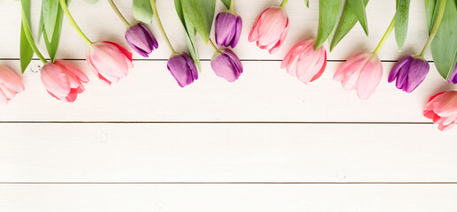 pink and purple tulips over white wooden table background