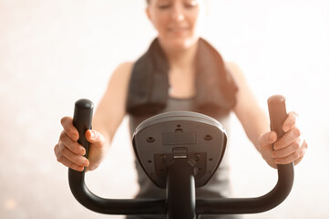 The girl is engaged on an exercise bike at home very close-up, small depth of field.