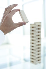 Human hand pulls out detail of jenga game in office