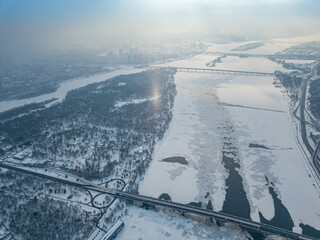 Light pillar from the sun over the Dnieper river in Kiev. Aerial drone view. Winter sunny morning.