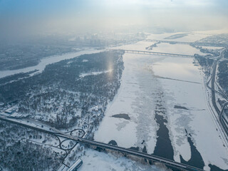 Light pillar from the sun over the Dnieper river in Kiev. Aerial drone view. Winter sunny morning.