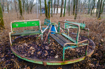 Abandoned children's camp. An old playground. Rusty carousel, rusty swing.
