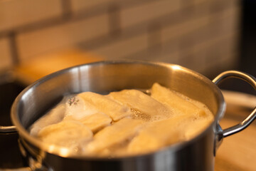 Dumplings are boiled in boiling water on a kitchen stove