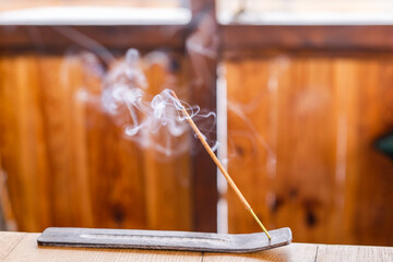 Smoking incense stick on a stand close-up