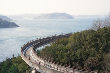 日本の来島海峡大橋にある自転車道でサイクリングを楽しむ人　ナショナルサイクルルート「しまなみ海道サイクリングロード」