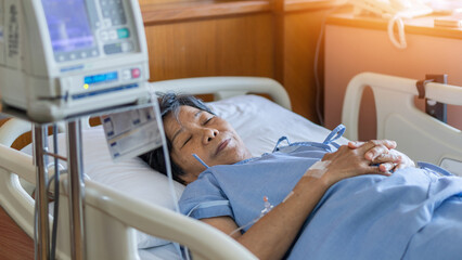 Hospitalized elderly patient senior woman sleeping on bed in hospital ward room with iv medical...