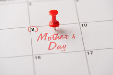 Happy mother's day concept. Cropped close up view photo of red pushpin attached to calendar with...