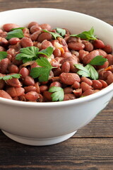 Vegetarian red bean stew with herbs and spices on a wooden table. Vertical orientation
