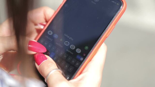 Writes a message on a mobile phone. Phone in his hands.  