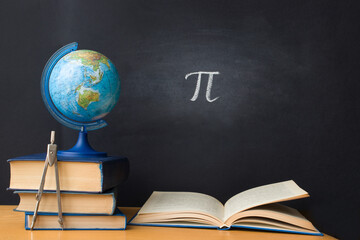 The Greek letter Pi, the ratio of the circumference to its diameter, is drawn in chalk on a black...