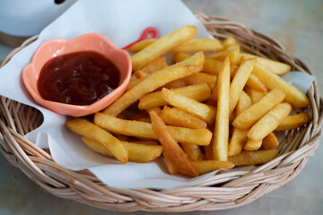 Potato chips in a basket with ketchup