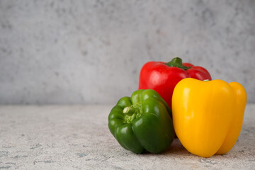 Fresh juicy bell peppers on a gray background