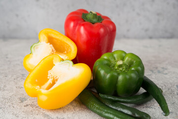 Fresh juicy bell peppers on a gray background