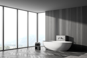 Fototapeta na wymiar Wooden grey bathroom with bathtub and towels near window