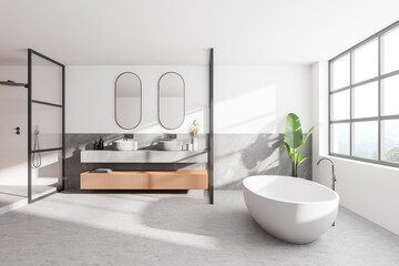Naklejka na ściany i meble Interior of modern bathroom with white and wooden walls, concrete floor, double sink with two mirrors above it and comfortable white bathtub.