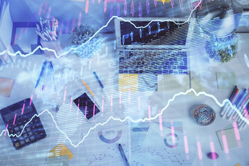 Double exposure of forex chart drawing over table background with computer. Concept of financial research and analysis. Top view.