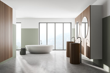 Interior of modern bathroom with white and wooden walls, concrete floor, two sinks with two round mirrors above it and comfortable white bathtub.