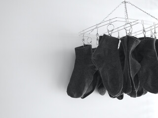 Gray socks are dried on, Stainless steel hanging rack indoor on white background with copy space, Washing socks with detergent for cleanliness and hygiene.