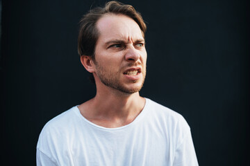 Obraz premium Angry man clenched his teeth in anger at dark wall