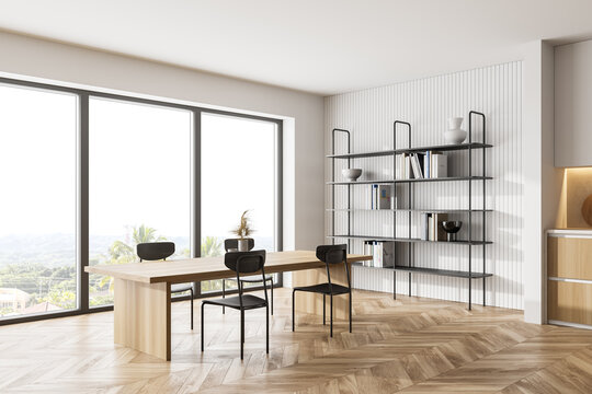 Wooden kitchen room with dining table and chairs near window, parquet floor
