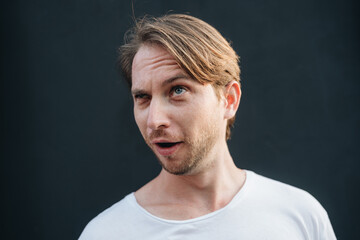 Portrait of crazy man at dark wall