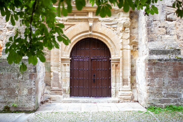 Portón de madera antiguo en pared de piedra medieval