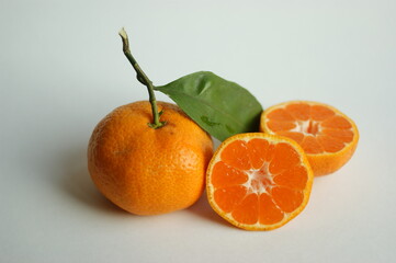 ripe and juicy tangerine (mandarin). fresh tangerine with leaf on white, closeup