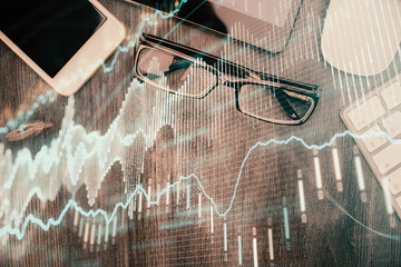 Multi exposure of forex graph hologram over desktop with phone. Top view. Mobile trade platform concept.