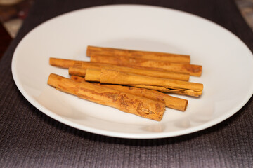 Cinnamomum verum, Called true cinnamon tree, cinnamon stick on white plate, gastronomy concept