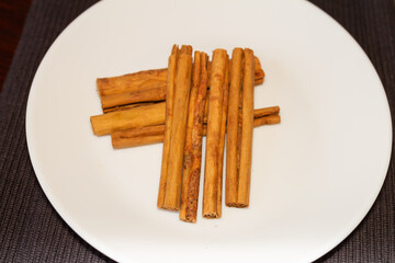 Cinnamomum verum, Called true cinnamon tree, cinnamon stick on white plate, gastronomy concept