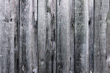 A fence made of old boards. The boards are gray.