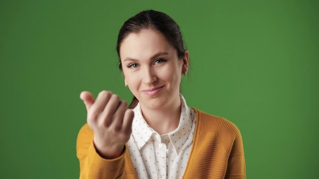 Woman beckoning finger gesture. Happy positive smiling woman on chroma key background looking at camera and invite gesture asks to come to her. Slow motion