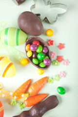 Easter set with colorful eggs, carrots, candy, cupcake. Top view.
