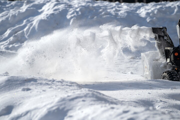 Snow removal with a snowblower. Flying snow, large drifts. Place for text