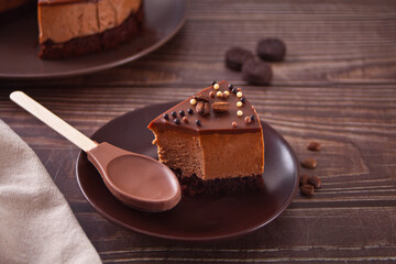 chocolate cheese cake on the wooden table with chocolate spoon