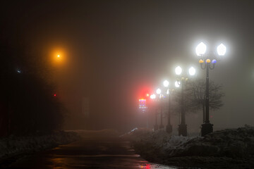Foggy night scenery with lights of the lamp posts in the city