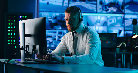 Male operator using computer in surveillance center