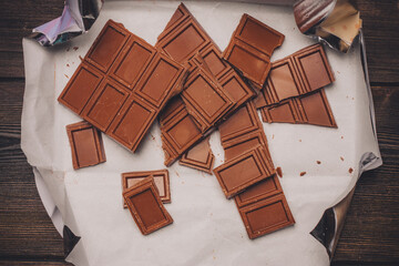 chocolate cubes broken on brown paper on the table
