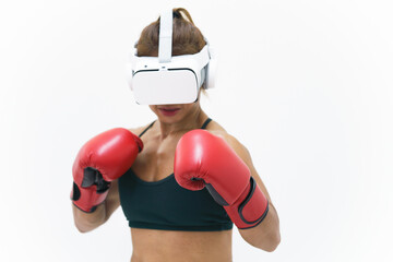 Medium close up shot of Asian woman wearing VR headset to exercise with simulation boxing games, Young female athlete boxer virtual reality combat experience activity. Boxing gloves selective focused.