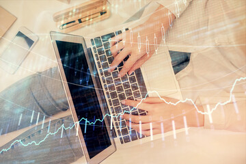 Double exposure of woman hands working on computer and forex graph hologram drawing. Top View. Financial analysis concept.