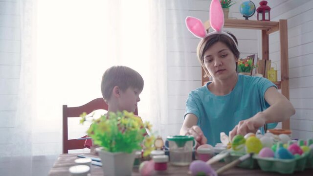 Happy easter. Family mother with son painting eggs for easter