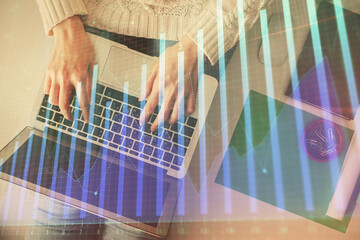 Double exposure of woman hands working on computer and forex chart hologram drawing. Top View. Financial analysis concept.