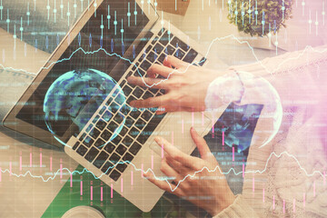 Double exposure of woman hands working on computer and forex chart hologram drawing. Top View. Financial analysis concept.