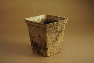 Coconut Coir Pot made from coconut fiber natural material on brown background. Plants pot made from coconut fibre. Environmental Green friendly concept. Vertival banner, Free copy space..